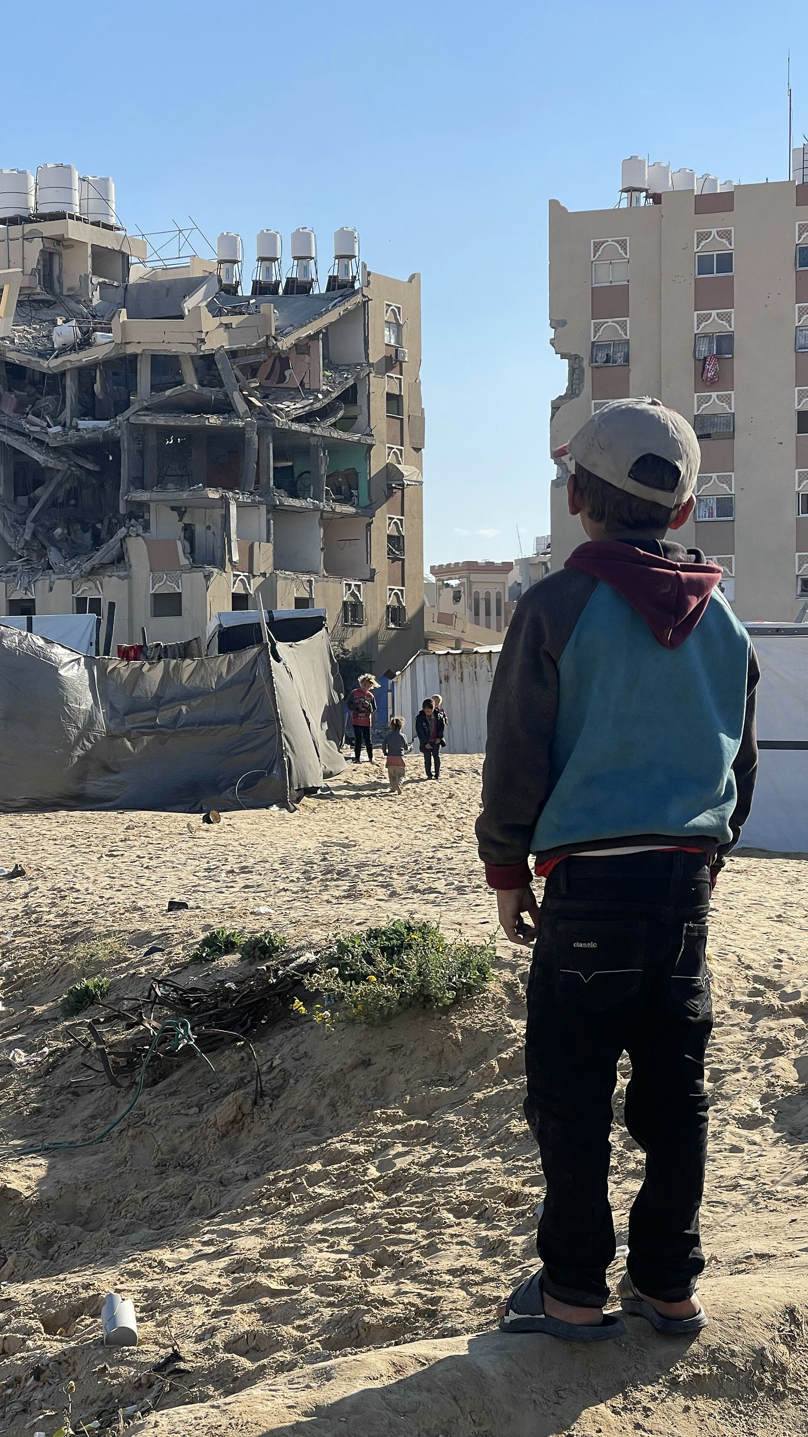 طفل ينظر إلى مبانٍ مدمرة في غزة (أرشيف)