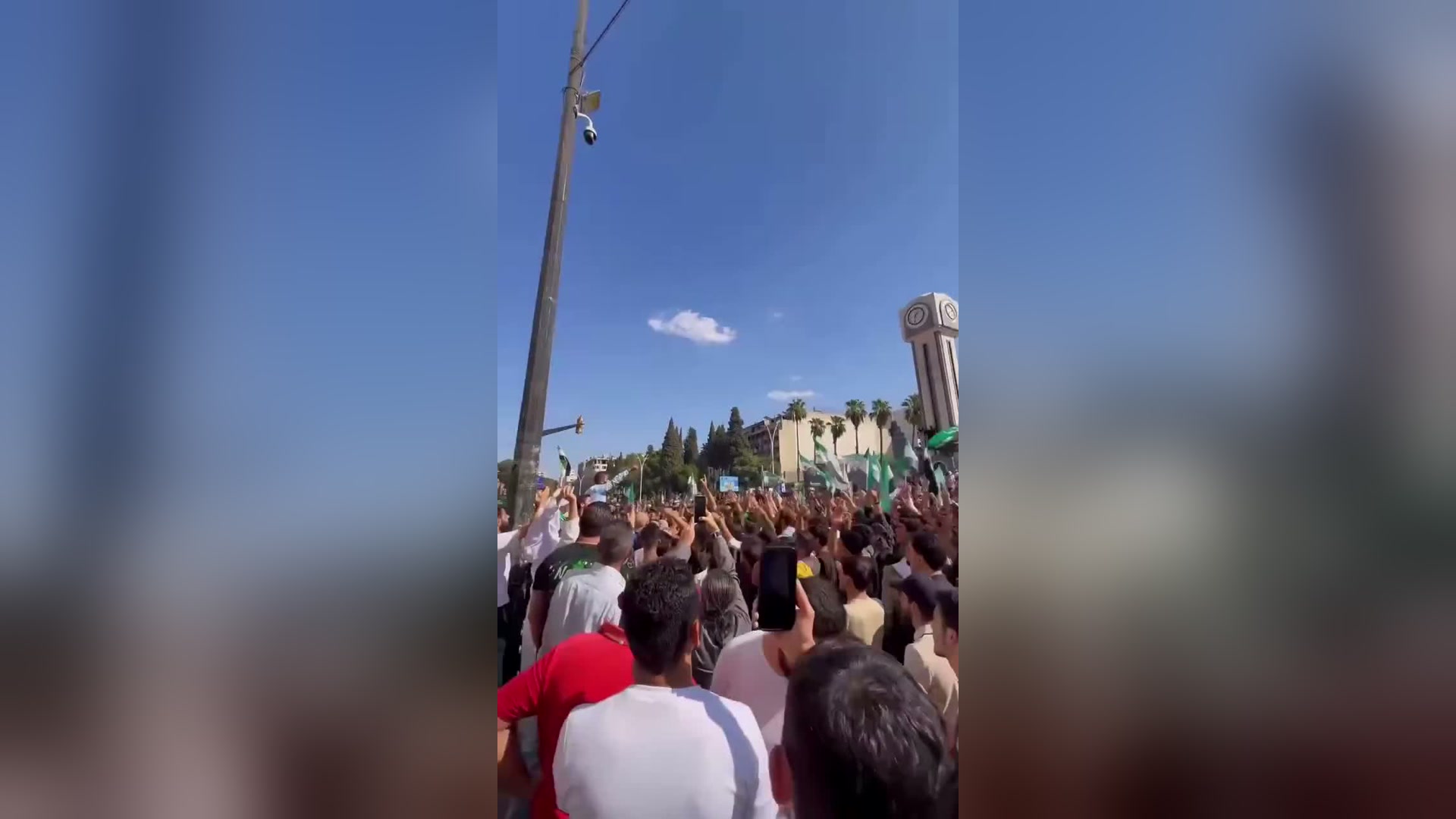 Толпы людей поднимают сирийские флаги во время демонстрации в Хомсе