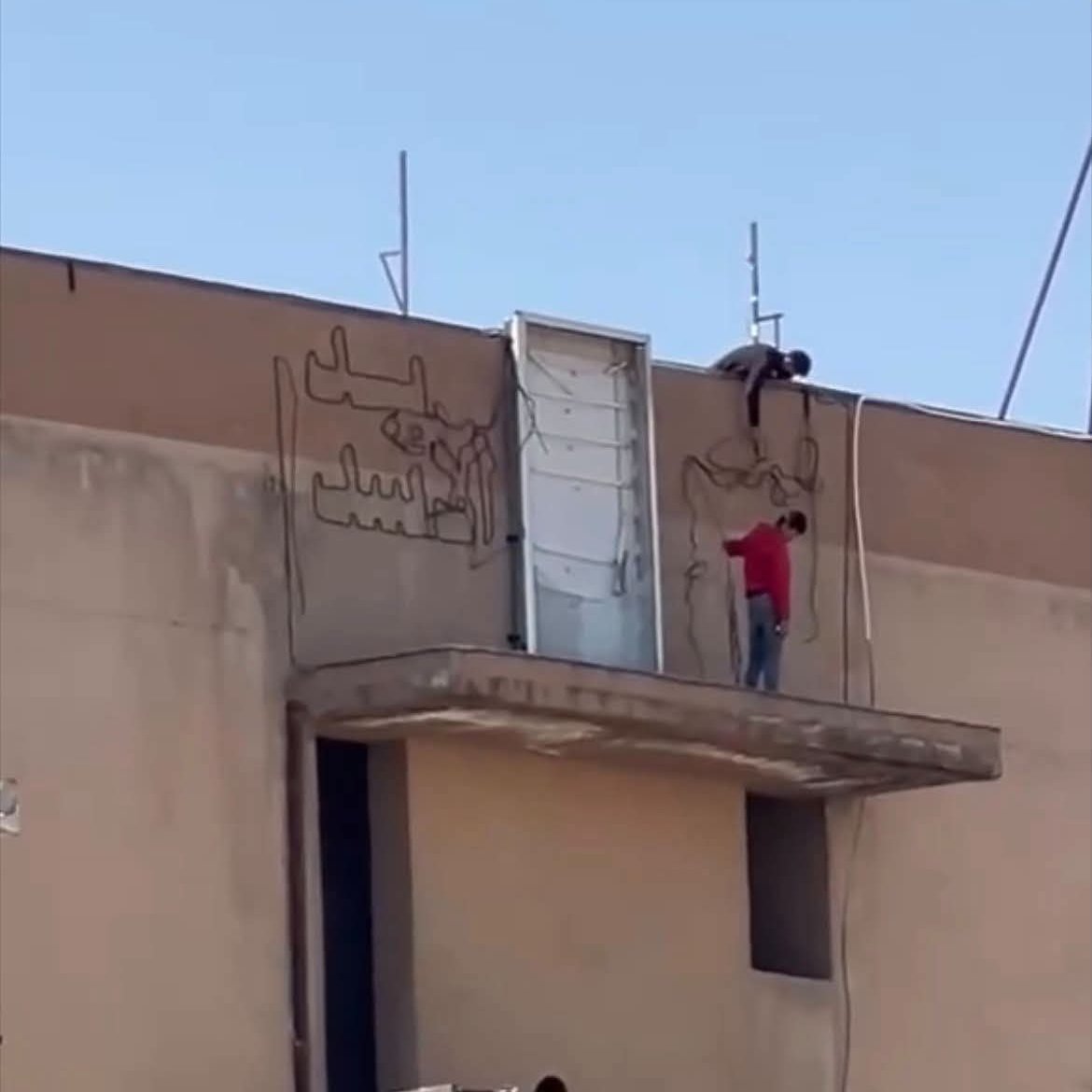 إزالة كتابات ورموز عن مبنى في الحسكة