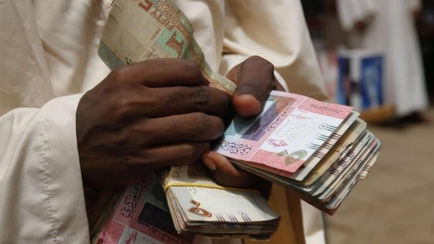 رجل يعد أوراقا نقدية سودانية