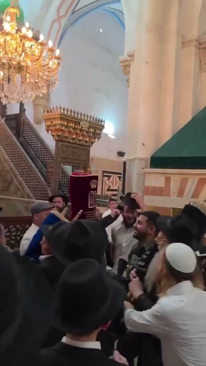 A frame from footage showing settlers dancing with Torah scrolls inside the Ibrahimi Mosque