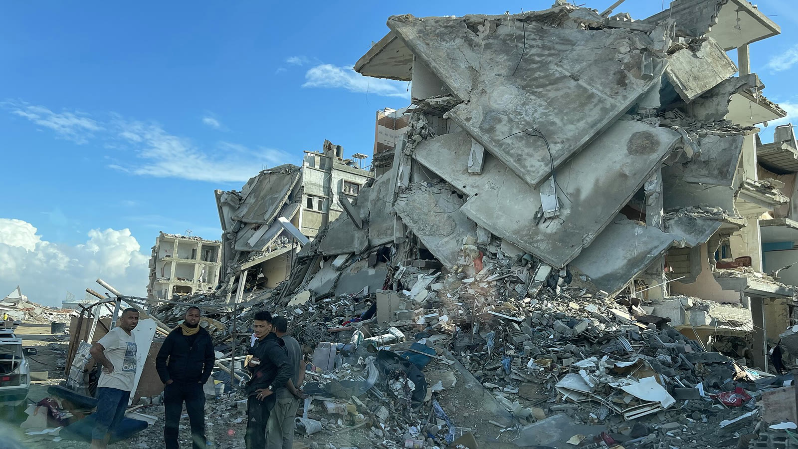Gazze'de yıkılan evlerin enkazı çevresinde toplanan insanlar (arşiv)